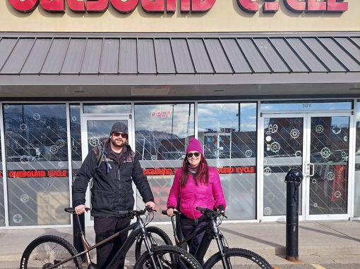 couple with bikes outside bike shop